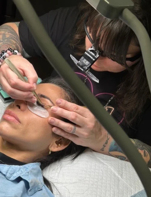 Overhead shot of Dominique applying lash extensions to a client
