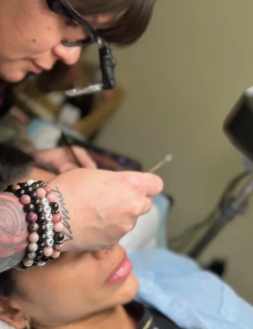Dominique applying lash extensions to a client