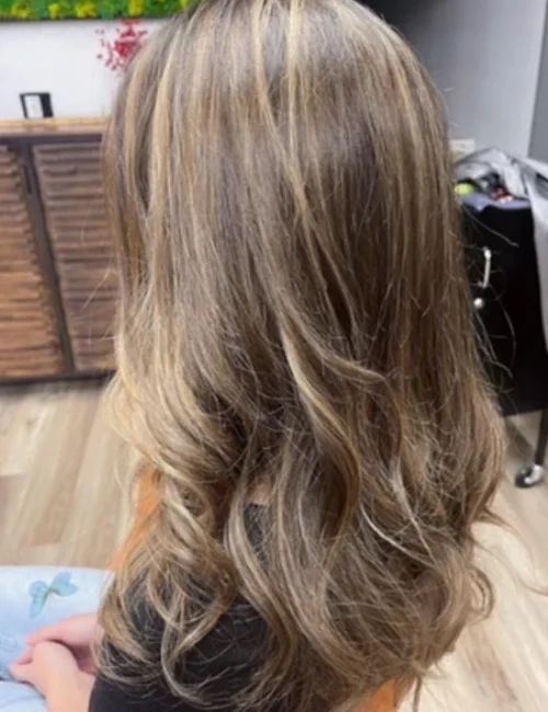 Side profile of a woman's new haircut and color