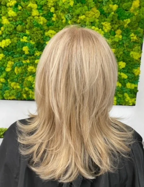 Back view of a woman's hair with a fresh cut and blonde coloring
